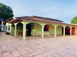 a small green house with chairs and a table at Casa de praia em mmosqueiro para Cop 30 Belém in Belém