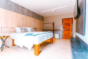 a bedroom with a bed and a wooden wall at Hotel Casa do Mar in Icapuí