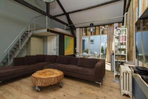 een woonkamer met een bank en een tafel bij Paardenstal, Private House with wifi and free parking for 1 car in Weesp