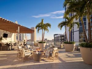 un patio con sillas, mesas y palmeras en AVE Tampa Riverwalk, en Tampa