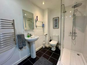 a bathroom with a sink and a shower and a toilet at Penthouse with City Views in Bristol