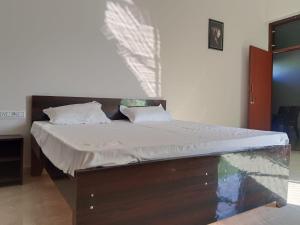 a bed with white sheets and pillows in a room at Riya Home Stay in Sawāi Mādhopur