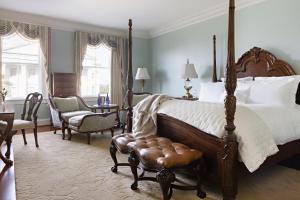 a bedroom with a large bed and a chair at Market Pavilion Hotel in Charleston
