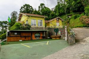 a building with a tennis court in front of it at VELINN Pousada Casa de Campos Capivari House in Campos do Jordão +37 photos