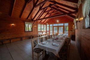a dining room with a long table in a building at Vidéki Vendégház - Pensiune Rurală in Bisericani