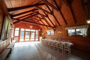 a dining room with tables and chairs in a building at Vidéki Vendégház - Pensiune Rurală in Bisericani
