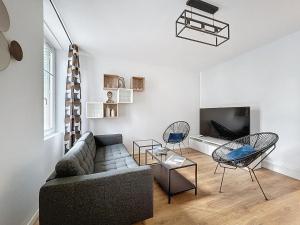 a living room with a couch and chairs and a tv at Appartement neuf, 4 Chambres ,Spacieux TV-WIFI in Clermont-Ferrand