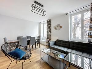 a living room with a couch and a table at Appartement neuf, 4 Chambres ,Spacieux TV-WIFI in Clermont-Ferrand