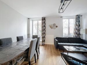 a living room with a table and a couch at Appartement neuf, 4 Chambres ,Spacieux TV-WIFI in Clermont-Ferrand +9 photos