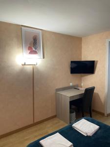 a hotel room with a desk and a bed and a computer at Auberge du pont canal in Briare