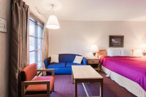 a hotel room with a bed and a blue couch at Gatlinburg Motel in Gatlinburg