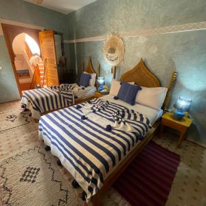A bed or beds in a room at Riad Jenan Adam