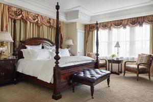 a bedroom with a canopy bed and a chair at Market Pavilion Hotel in Charleston