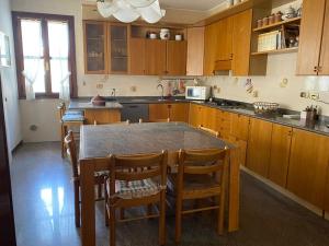 a kitchen with wooden cabinets and a table with chairs at Betty House in Legnaro