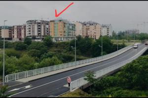 a red arrow points to a highway with buildings at Sunny place in Podgorica
