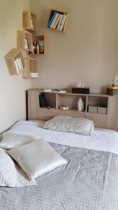 a bed with two pillows on it in a room at Maison de vacances ou chambres d'hôtes belle campagne auvergnate in Saint-Julien-la-Geneste