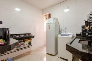 a kitchen with a white refrigerator and a sink at Apto 2 suítes no Bueno, perto do Goiânia Shopping in Goiânia