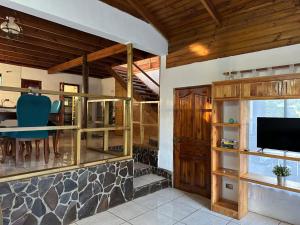 a living room with a table and a tv in a house at Casa Takarua in Hanga Roa