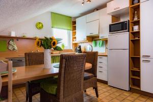 Una cocina con una mesa con sillas y un refrigerador. en stay with friends Trier 2, en Trier