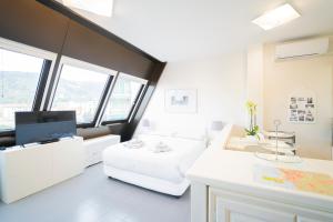 Una habitación blanca con una cama y un televisor. en La Casetta Sestri Levante, en Sestri Levante