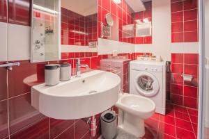 baño de azulejos rojos con lavabo y lavadora en La Casetta Sestri Levante, en Sestri Levante 22 fotos más