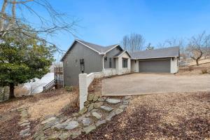 a house with a driveway and a garage at Dock Holiday - Hot Tub - Private Dock in Bella Vista