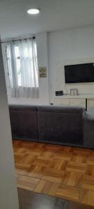 リオデジャネイロにあるGuest House em Botafogo - vista, tranquilidade e camas individuais em ambiente exclusivo para até 5 hóspedes -acesso somente por escadasのソファとテレビのあるリビングルーム