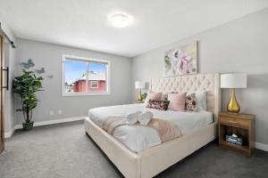sypialnia z dużym łóżkiem i oknem w obiekcie NEW! Large Family 4BR w Kid's Play Den, Yard - FREE Banff Pass, BBQ, Netflix, Parking & Wine! w mieście Calgary