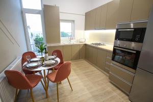 a kitchen with a table and chairs and a kitchen with a stove at Mianelly Center in Constanţa