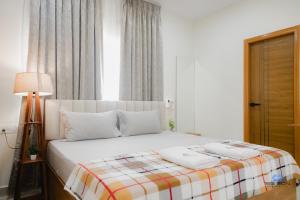 a bedroom with a white bed with a plaid blanket at Bigson Blissful Studios in Hyderabad