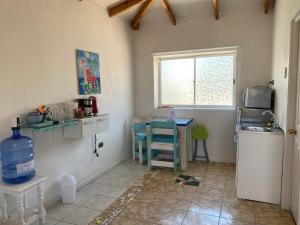 uma cozinha com um lavatório, uma mesa e uma janela em Estudio Los Mosaicos em Vicuña