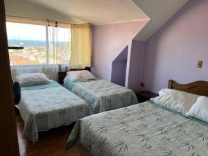 a hotel room with two beds and a window at Altos de Miramar in Puerto Montt
