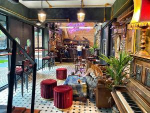 a woman sitting in a room with a piano at Dream Factory Hotel in Udon Thani