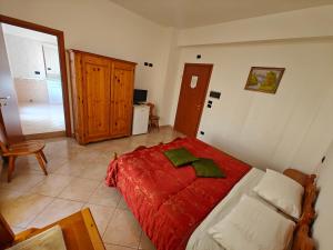 una camera da letto con un letto grande con una coperta rossa di Al Cedir a Reggio di Calabria