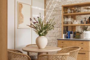 a table with a vase with flowers on it at One&Only Aesthesis, Athens in Athens