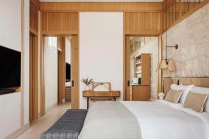 a bedroom with a large bed and a television at One&Only Aesthesis, Athens in Athens