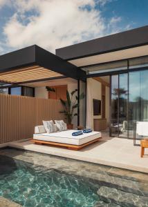 a bed on a patio next to a swimming pool at One&Only Aesthesis, Athens in Athens