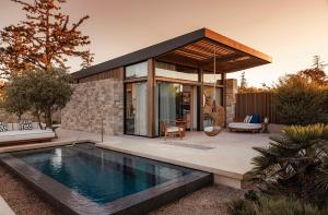 a house with a swimming pool in front of a house at One&Only Aesthesis, Athens in Athens