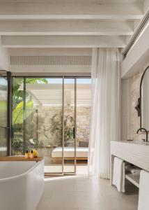 a bathroom with a bath tub and a window at One&Only Aesthesis, Athens in Athens