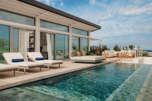 a villa with a swimming pool and a house at One&Only Aesthesis, Athens in Athens