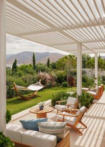 a patio with a couch and chairs and a hammock at One&Only Aesthesis, Athens in Athens