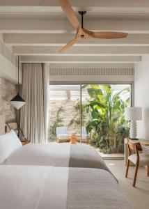 a bedroom with a bed and a ceiling fan at One&Only Aesthesis, Athens in Athens