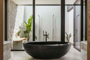 a bathroom with a large black tub in it at One&Only Aesthesis, Athens in Athens