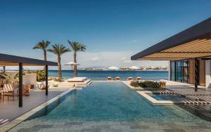 a swimming pool next to a resort with the ocean at One&Only Aesthesis, Athens in Athens