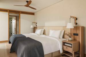 a bedroom with two white beds and a ceiling fan at One&Only Aesthesis, Athens in Athens