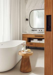 a bathroom with a white tub and a mirror at One&Only Aesthesis, Athens in Athens