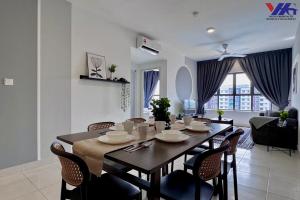 a dining room and living room with a table and chairs at Arena Designer Suite 3BR KLIA in Sepang