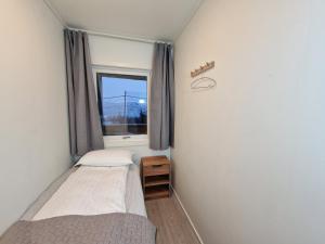 a small bedroom with a bed and a window at apartment With fantastic view and parking in Tromsø