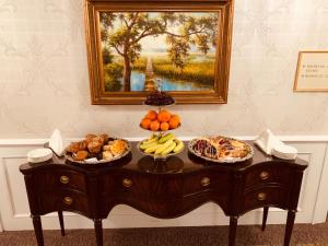 a table with fruit on it with a painting on the wall at Market Pavilion Hotel in Charleston