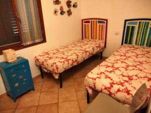 Villa Smeralda Costa Paradiso Sardinia holidays في كوستا باراديسو: غرفة نوم بسريرين وطاولة زرقاء ونافذة